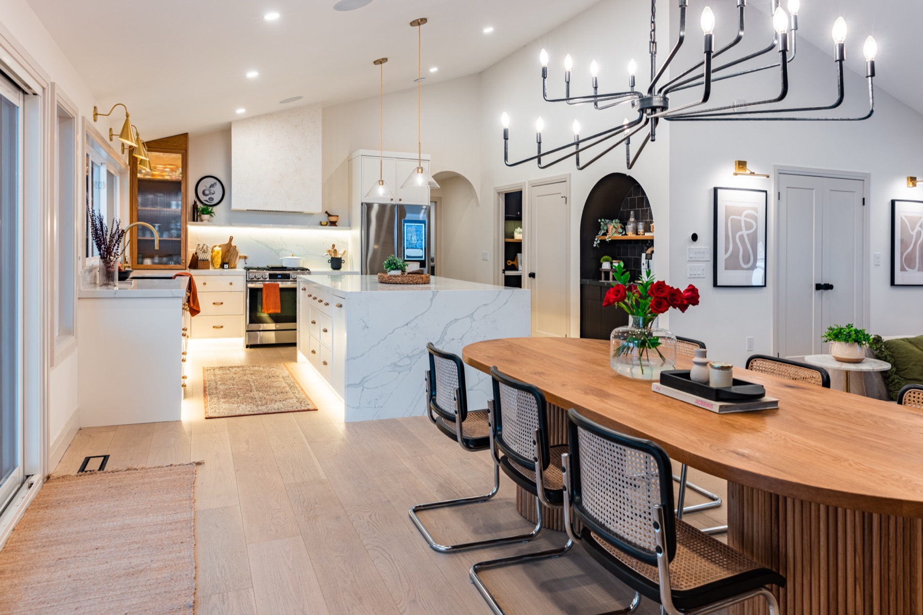 A calm kitchen styled with fresh roses, marble surfaces, and warm wood tones at The Whitehouse